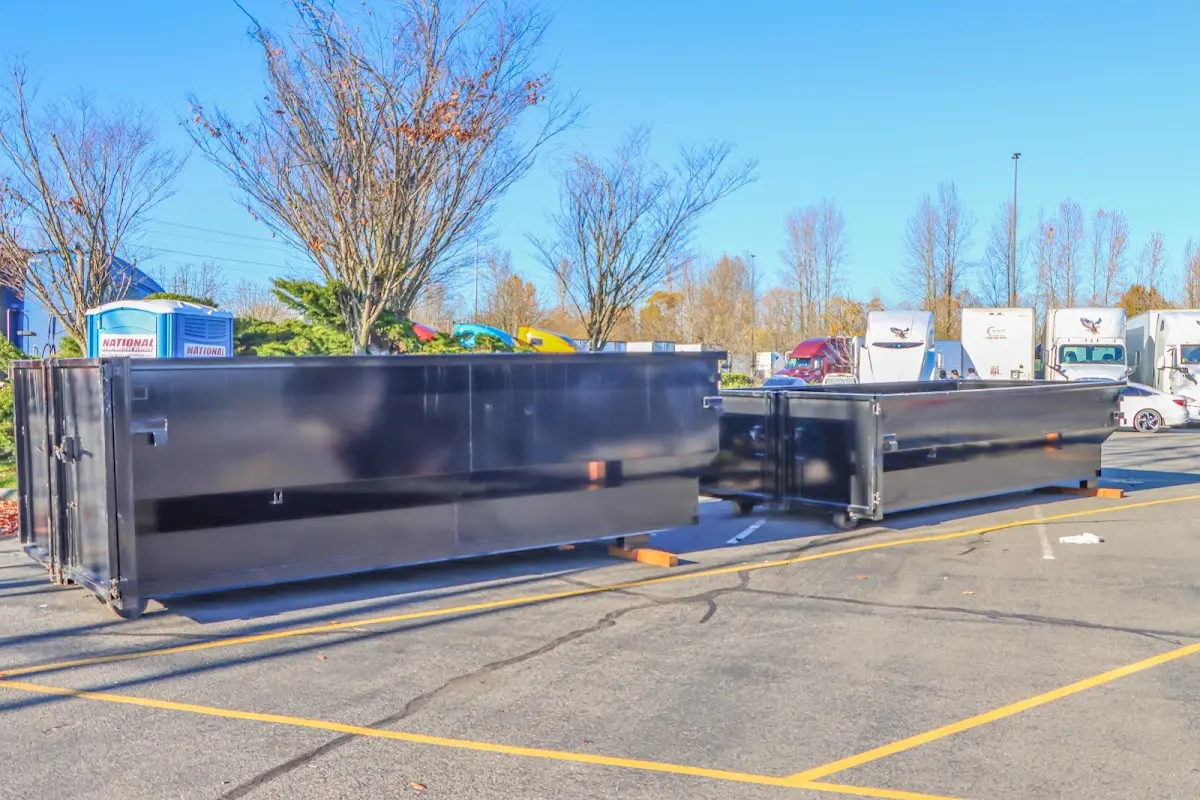 Professional dumpster rental service with roll-off container on residential driveway in Woodmoor